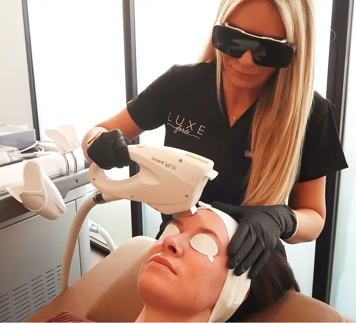 Practitioner in protective eyewear performing a laser treatment.
